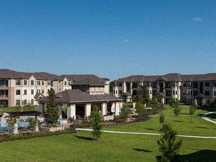 a group of apartment buildings on a green field