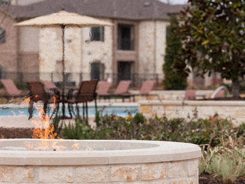 a pool and a fountain with a house in the background
