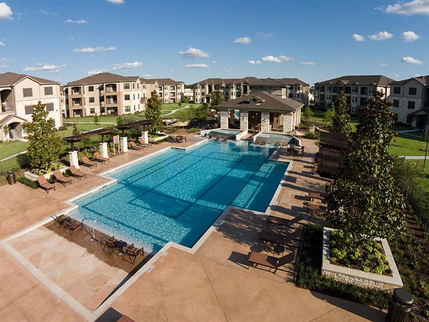 an aerial view of a swimming pool with apartments in the background
