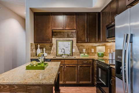 an updated kitchen with stainless steel appliances and granite counter tops