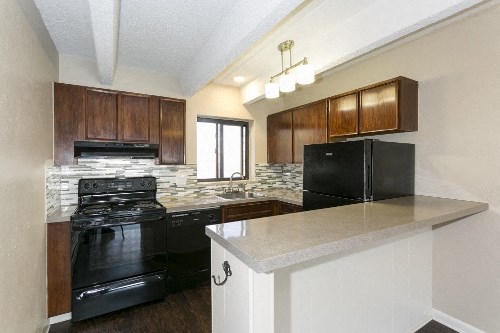 a kitchen with black appliances and a counter top