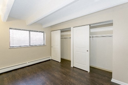 an empty bedroom with a closet and a window