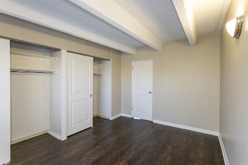 an empty living room with an open door to a closet