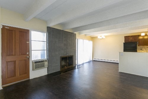 an empty living room with a fireplace and a wooden door