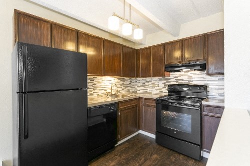 a kitchen with black appliances and wooden cabinets