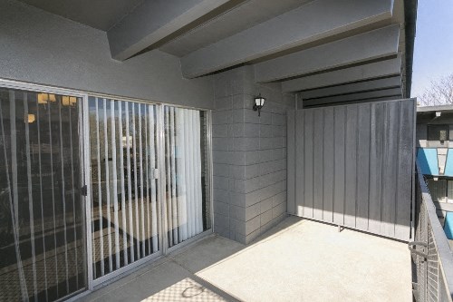 a patio outside of a house with a fence and a gate
