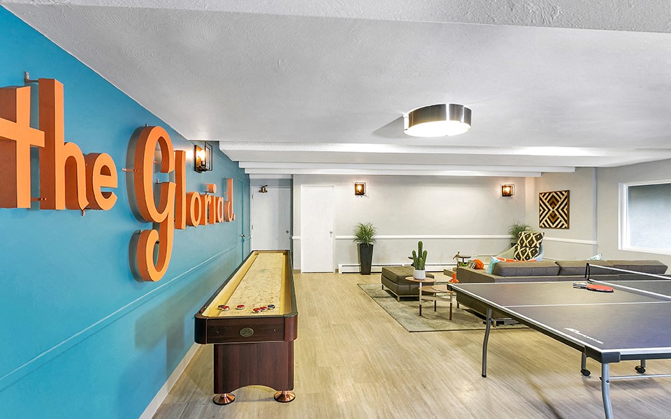a game room with a ping pong table and a blue wall with the goal