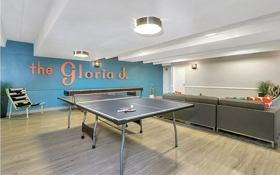 a games room with a ping pong table and a couch
