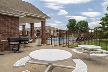 Community outdoor area with picnic tables and grills at The Northbrook in Lincoln
