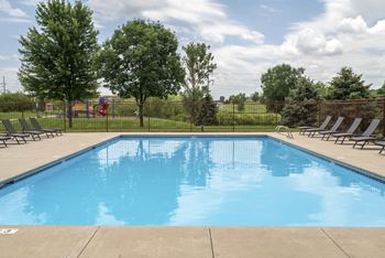 Large outdoor pool with lounge chairs at The Northbrook Apartments in Lincoln, NE