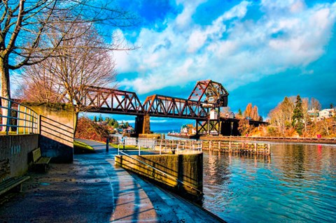 a train bridge over the water with a boat ramp