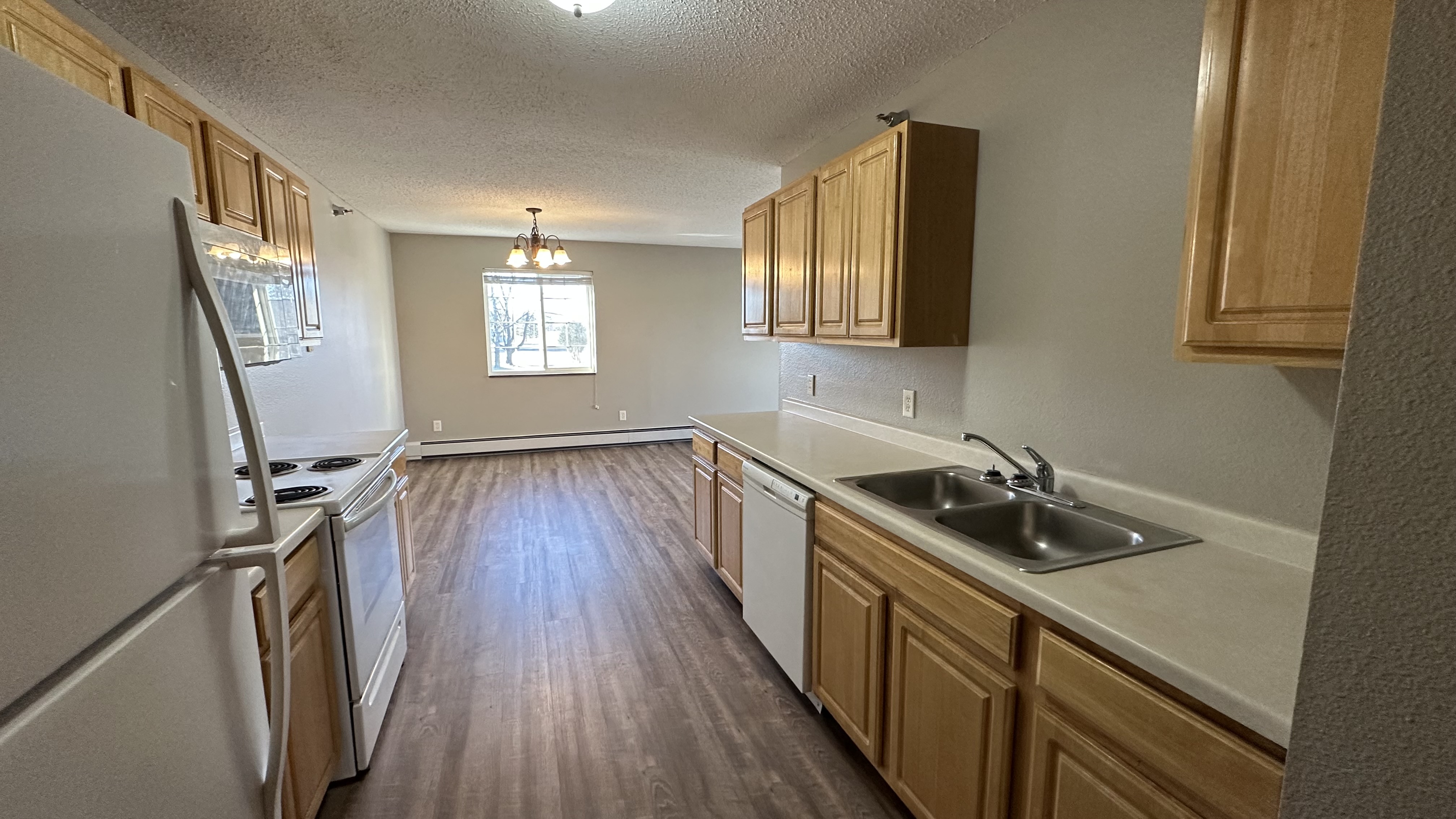 A kitchen with wooden cabinets and a white refrigerator.