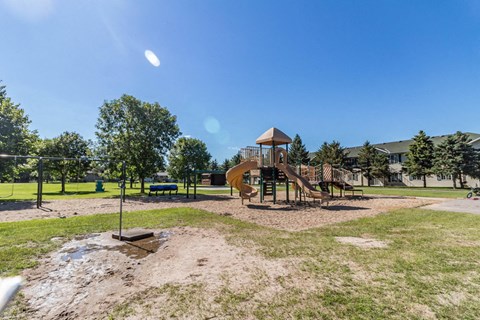 A playground with a slide and a swing set.