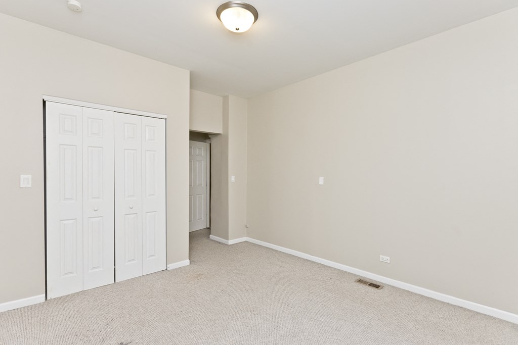 an empty bedroom with a closet and a door to the bathroom