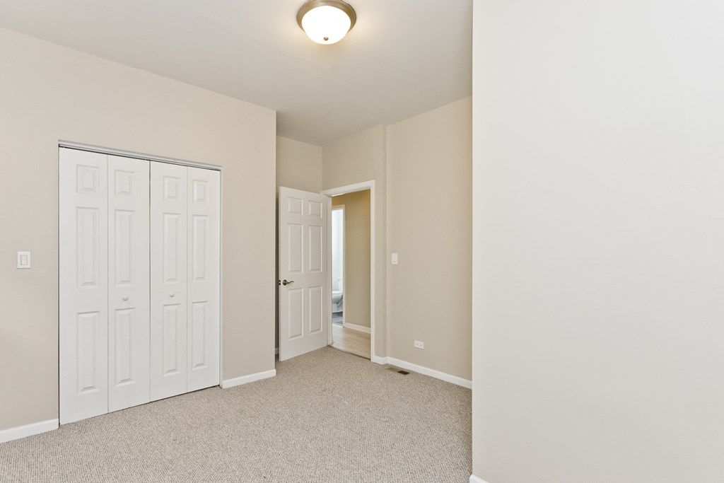 a bedroom with two closets and a door to a hallway