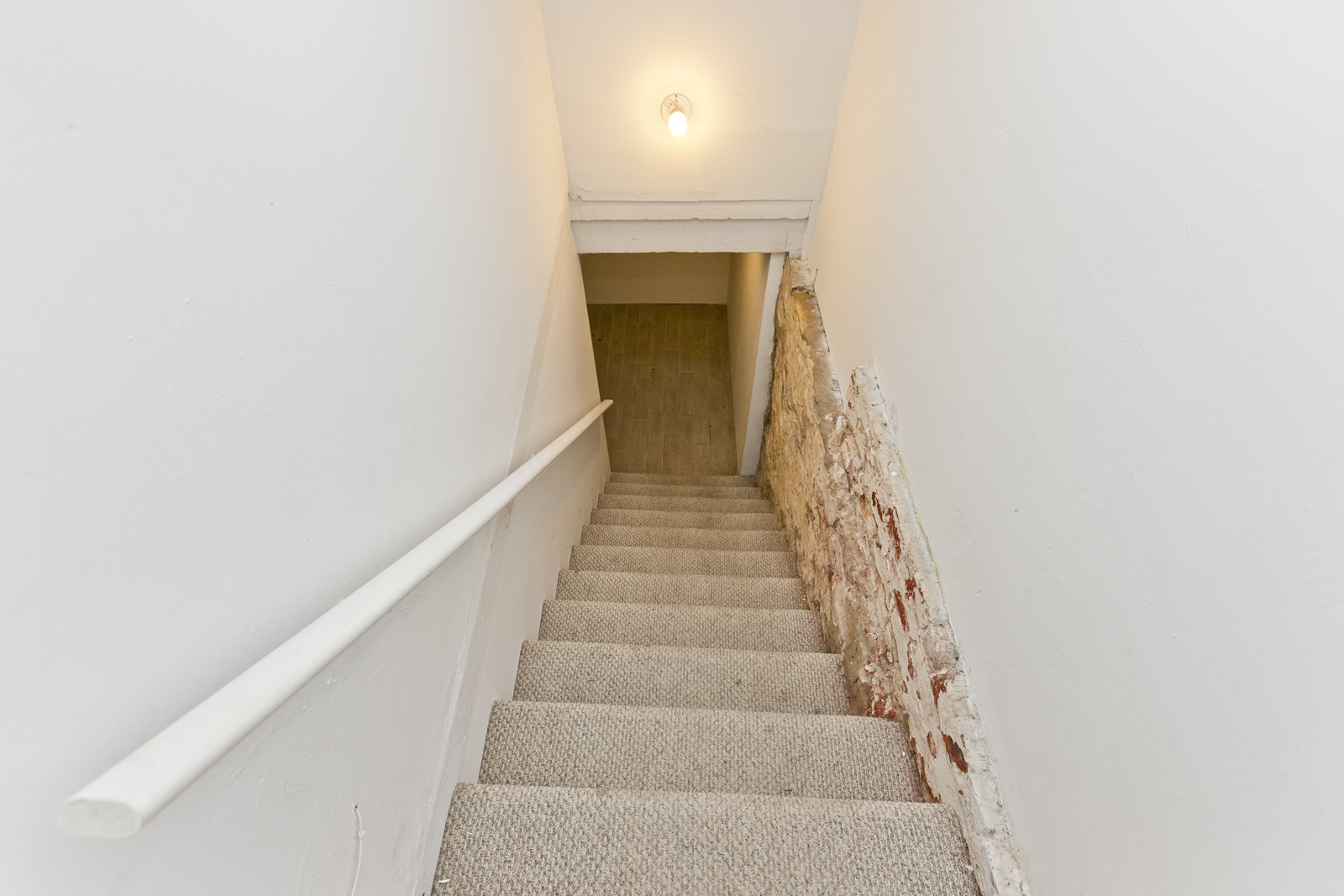 a set of stairs in a room with a wall and a stairwell with stairs