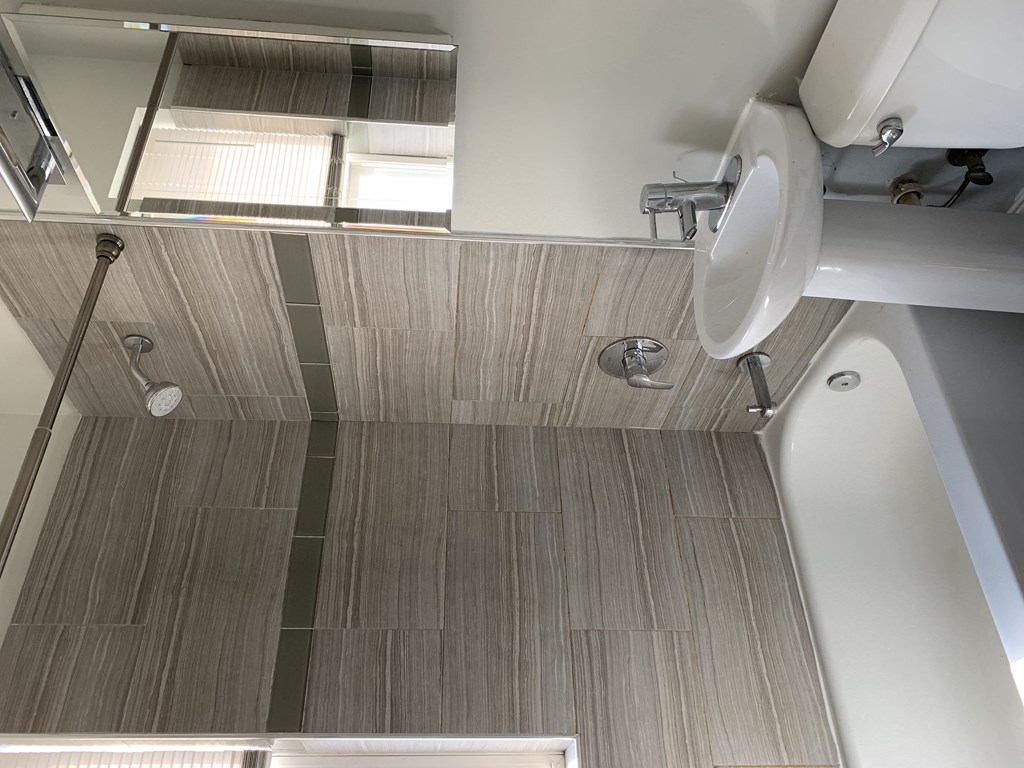 a bathroom with a shower and a sink and a toilet