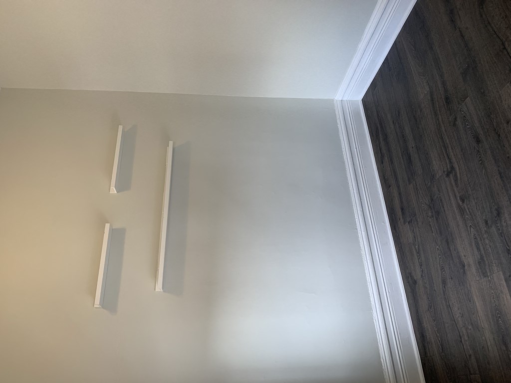 an empty room with white walls and wooden floors