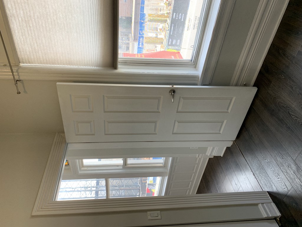 the view from the top of a staircase looking down at a window and a door