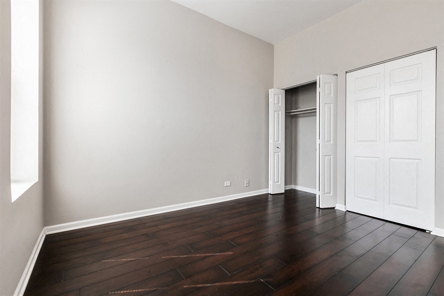 an empty living room with wood floors and white walls
