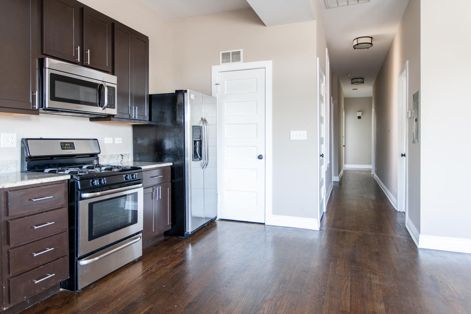 a kitchen with stainless steel appliances and wooden floors