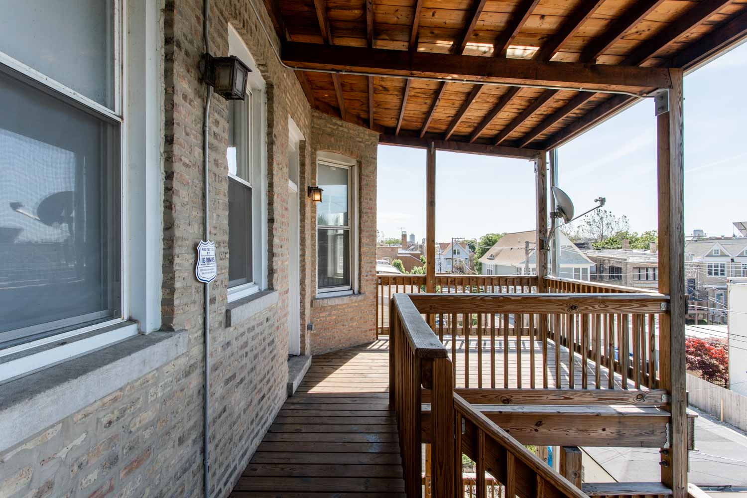 a porch with a wooden deck and a view of the city
