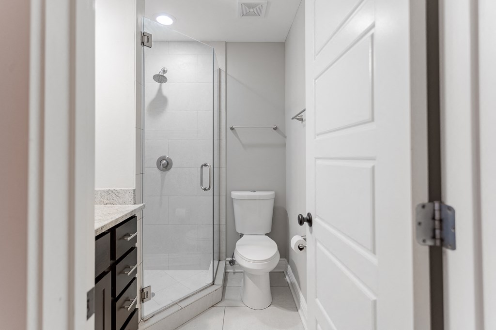 a white bathroom with a shower and a toilet