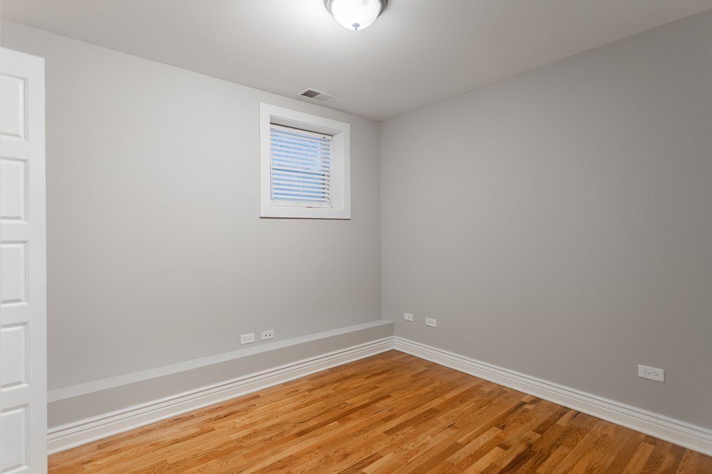 an empty room with wooden floors and a window