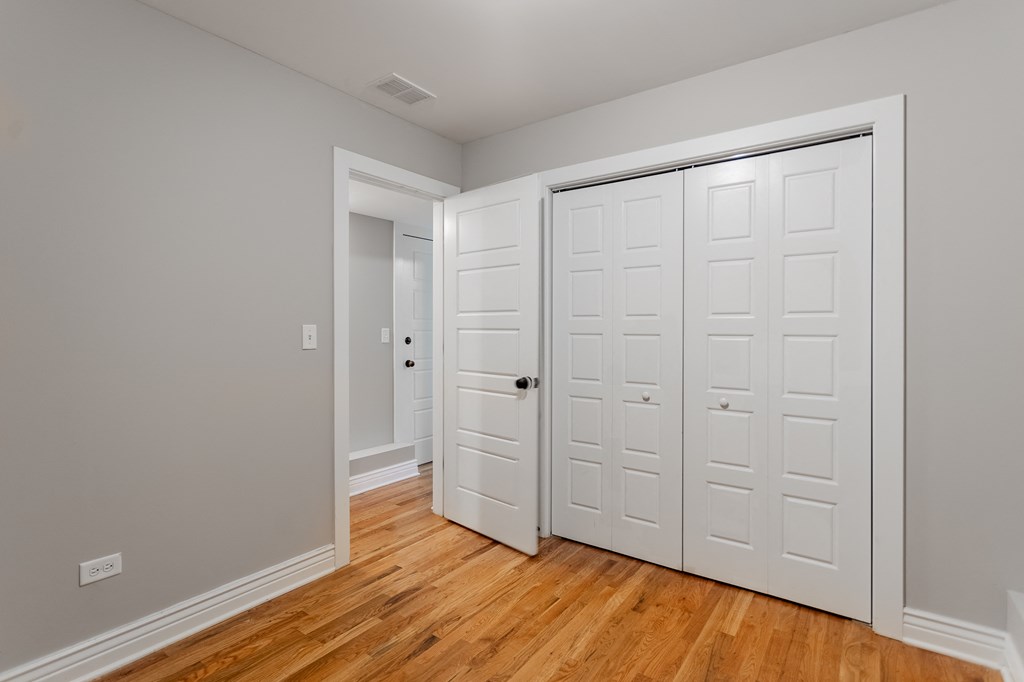 an empty room with two closets and a wood floor