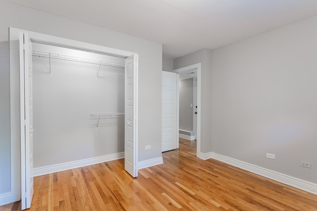 a bedroom with a closet and a hard wood floor