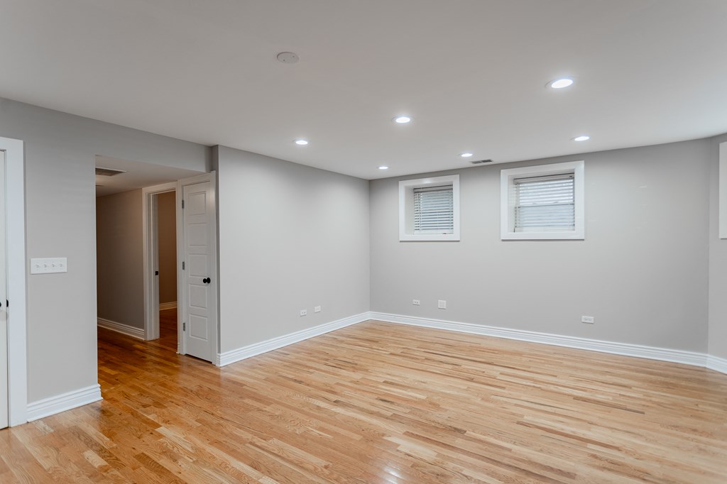a living room with a hard wood floor and grey walls