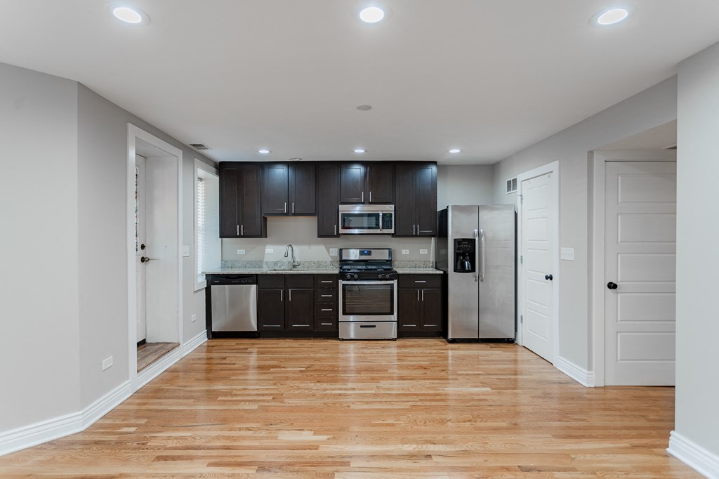 a renovated kitchen with black cabinets and stainless steel appliances