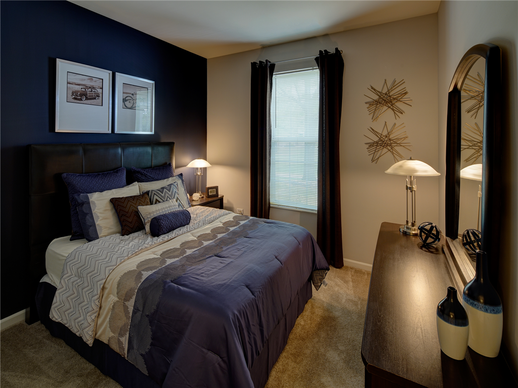 a bedroom with a bed and a dresser and a mirror