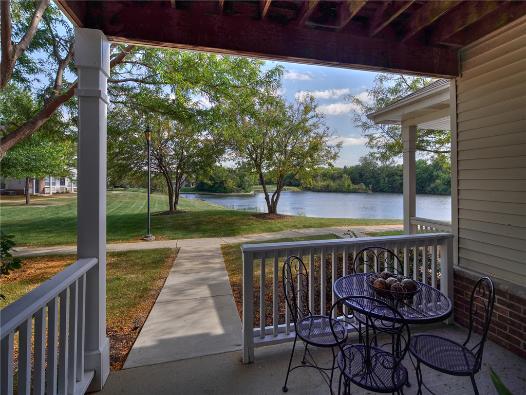 a patio with a table and chairs overlooking a lake
