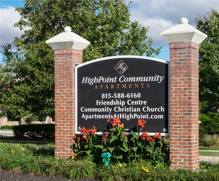 a sign for high point community apartments in front of a tree