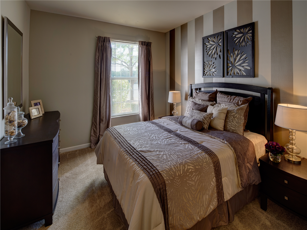 a bedroom with a bed and a dresser and a window