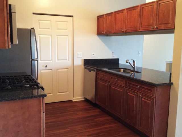 a kitchen with wooden cabinets and a refrigerator and a sink