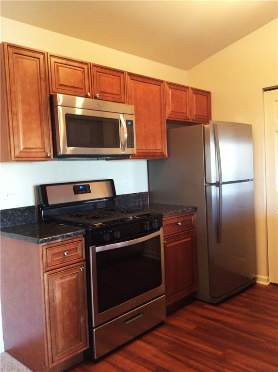 a kitchen with stainless steel appliances and wooden cabinets