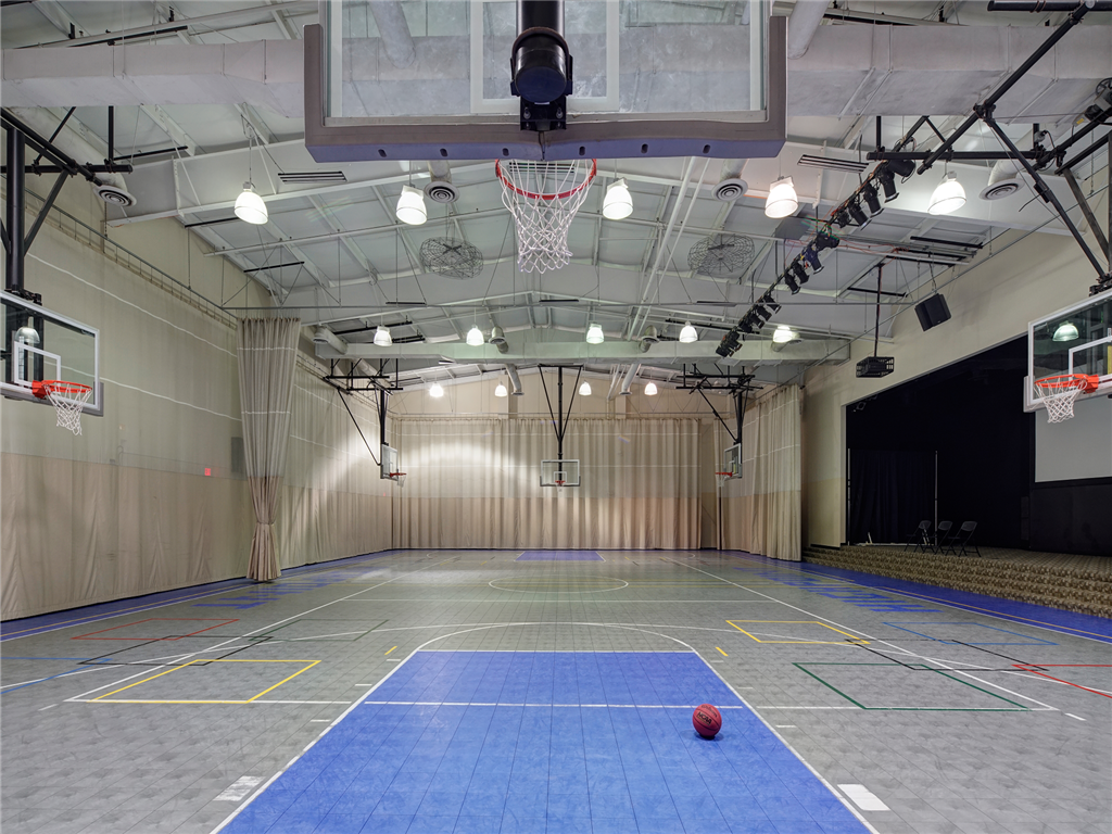 a basketball court in a gym with a basketball hoop