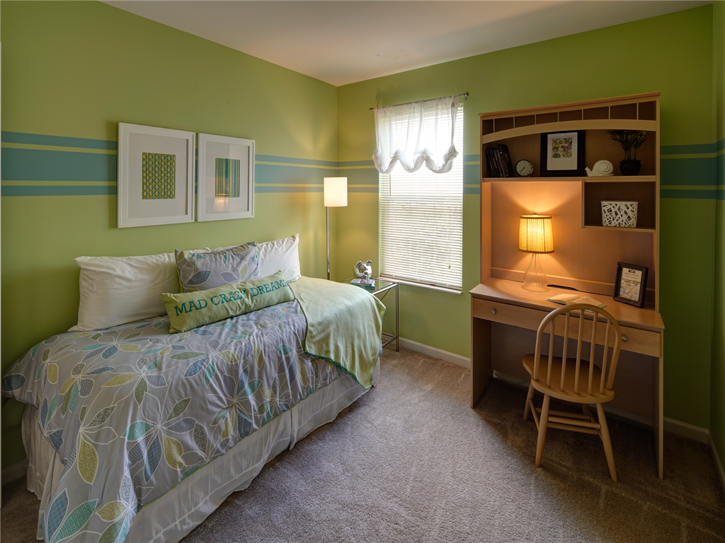 a bedroom with a bed and a desk with a chair