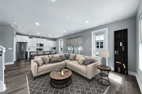A modern living room with a large sectional sofa and a coffee table in the center.