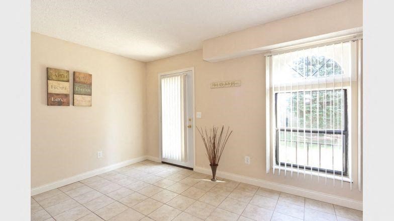 a empty living room with a large window and a door