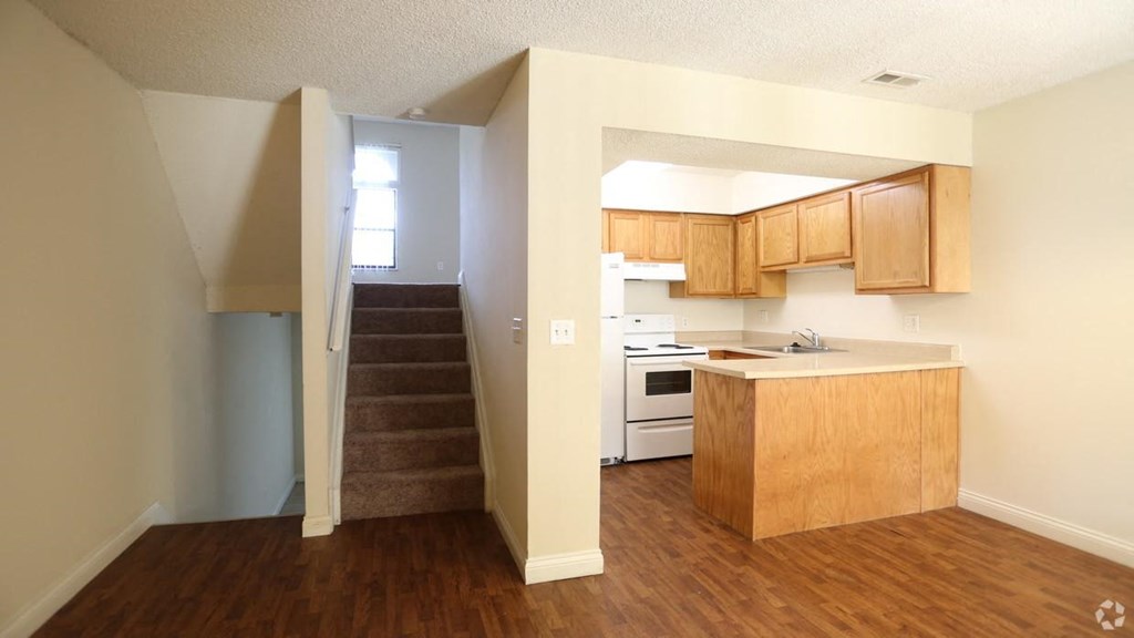 an empty kitchen and stairs in an empty house
