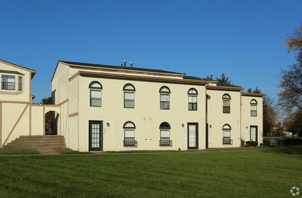 the front of a large house with a green lawn
