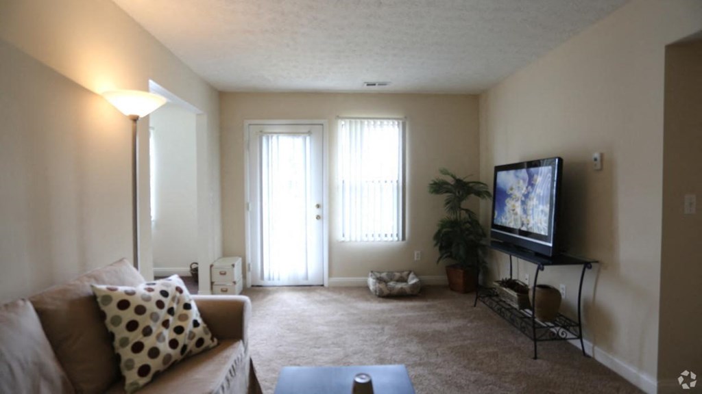 an empty living room with a couch and a tv