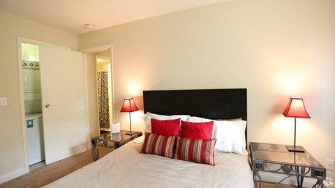 a bedroom with a bed and a table with two lamps