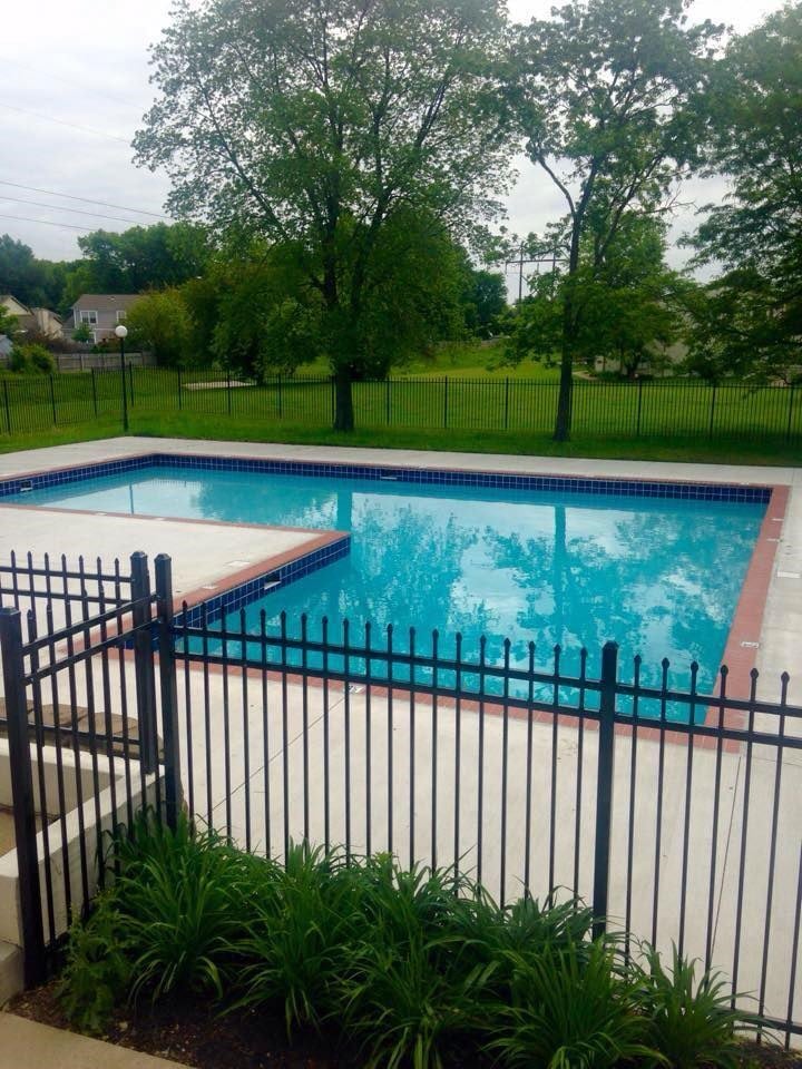 a large swimming pool behind a wrought iron fence