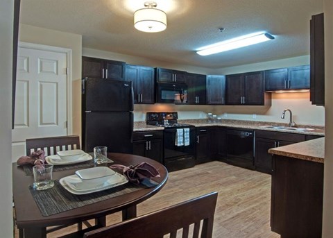 a kitchen and dining room with black cabinets and a table