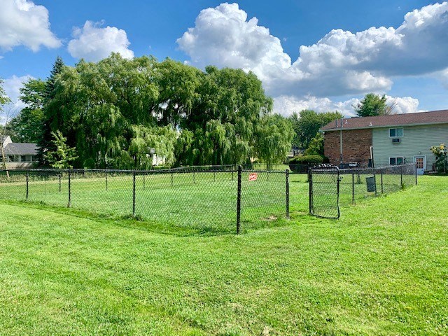a fenced in yard with a house and a tree