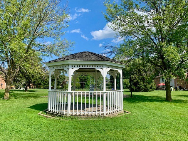 a white gazebo in the middle of a field